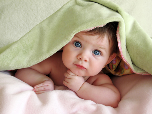 baby hiding under blanket