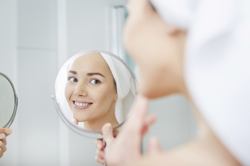 woman looking in mirror in bathroom