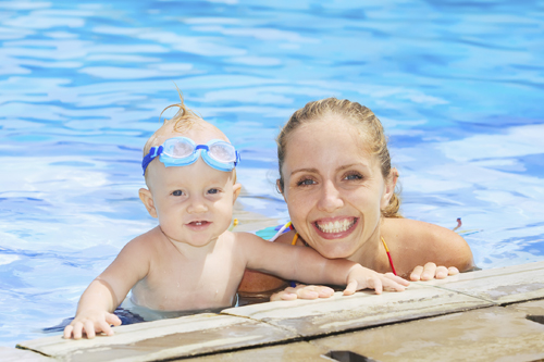 mother and baby boy with googles at swimming pool