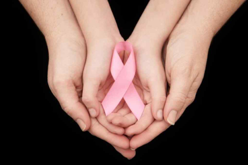 hands holding on to a breast cancer ribbon