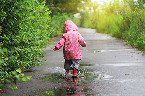 little girl walking in rain