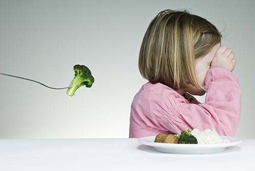 little girl refusing to eat broccoli