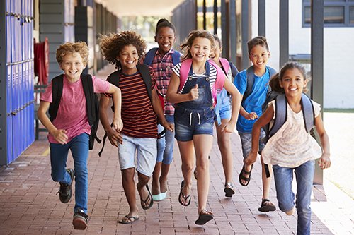 School kids running with backpacks on