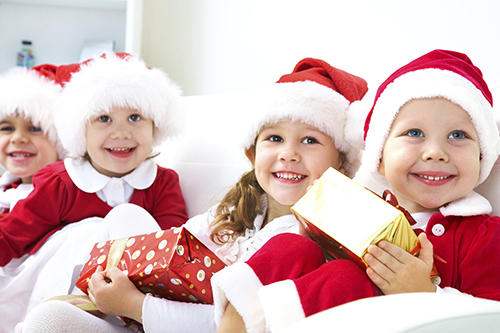 kids dressed up as santa holding presents