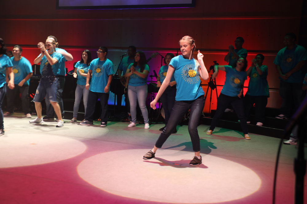 A girl strikes a pose while surrounded by other teens