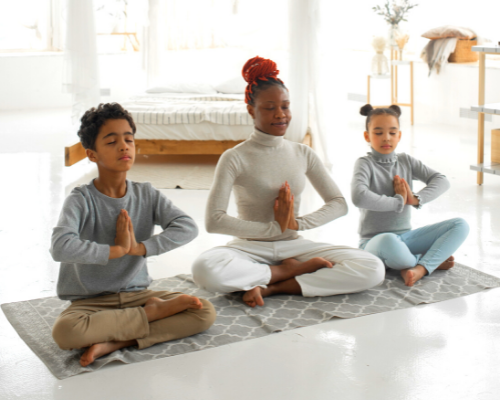 Mother meditating with son and daughter