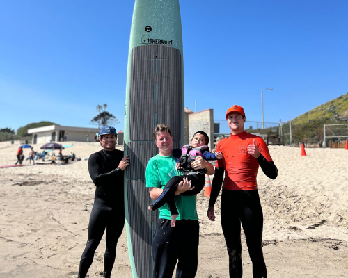 THERAsurf instructors and special needs child with surfboard
