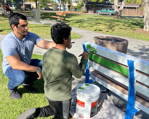 YMCA mentor and child painting bench