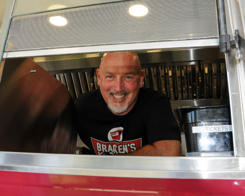 Chef Bill Bracken rising in his food truck window.