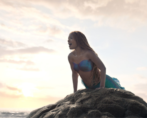 Halle Bailey as Ariel singing on rock in Disney's Live Action Little Mermaid